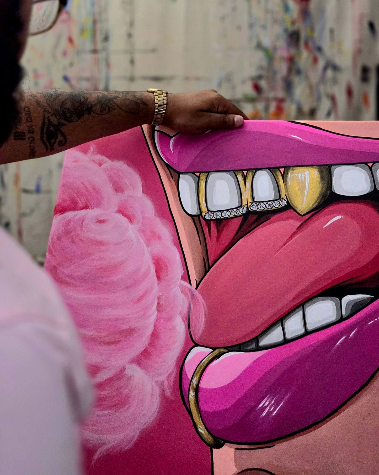 Person holding a large pink Surreal painting of a mouth with pink lips and gold grillz eating cotton candy